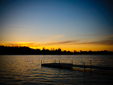 Dock on water at sunset